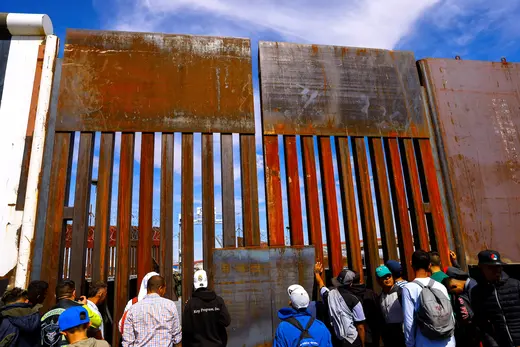 Migrants wait near the border wall, during a protest at the Paso del Norte international bridge to request asylum in the United States, seen from Ciudad Juarez, Mexico